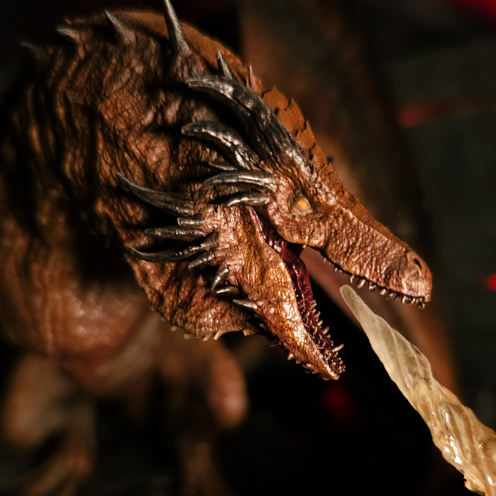 
                  
                    Gros plan sur la tête du dragon Bronze Fury rugissant, révélant ses crocs et ses cornes acérées dans une ambiance volcanique.
                  
                