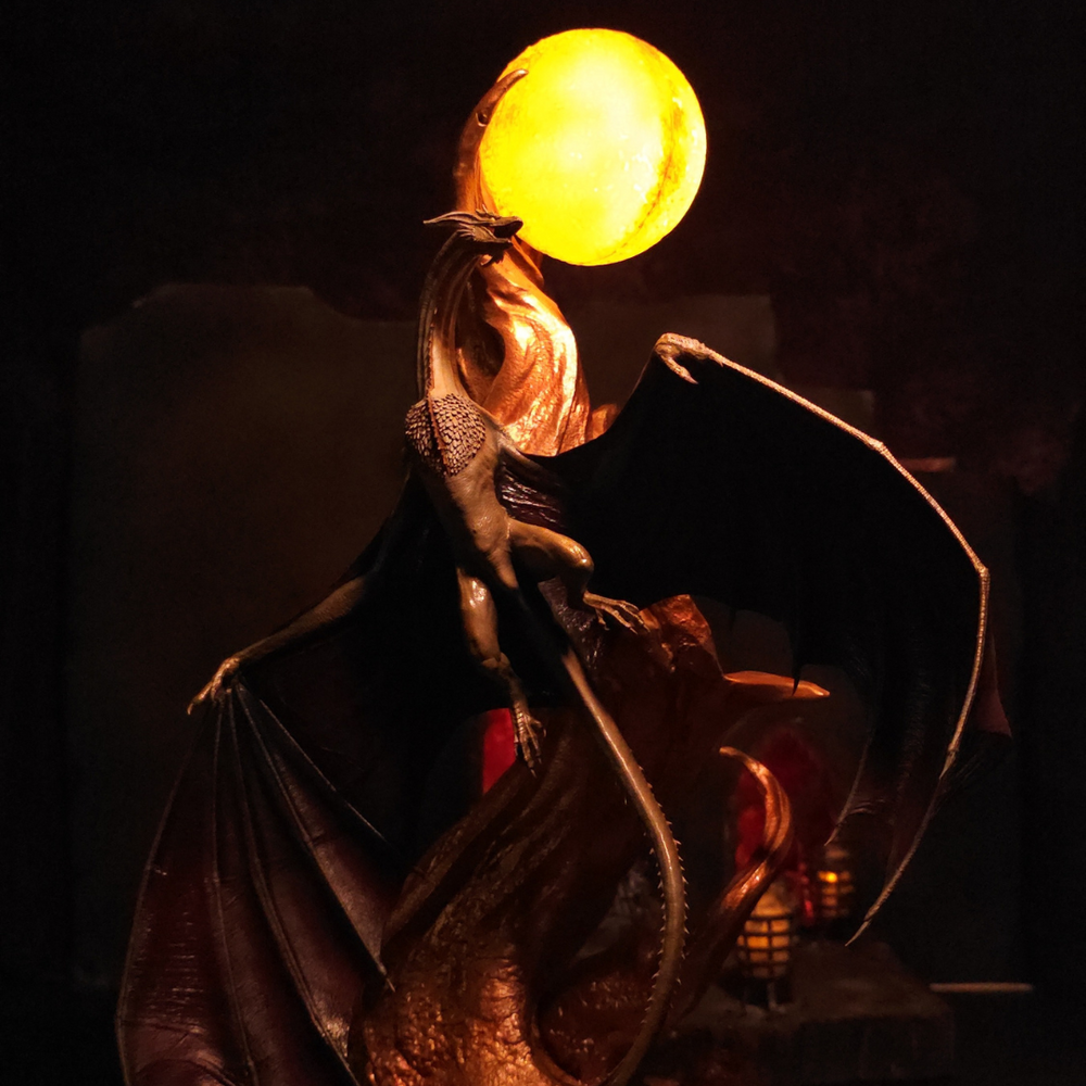 
                  
                    Dragon doré rugissant devant globe lumineux, détail figurine peinte à la main, style House of the Dragon
                  
                