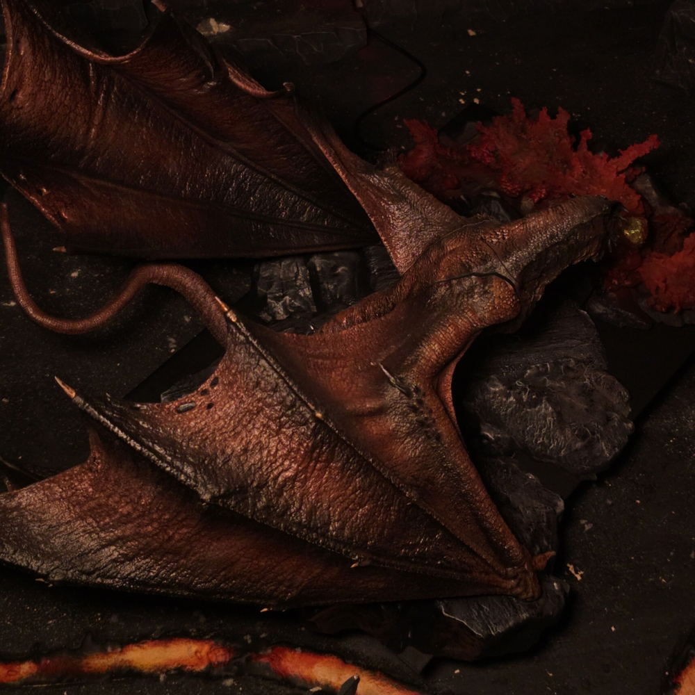 
                  
                    Vue aérienne des ailes du dragon sur fond de décor volcanique – Figurine inspirée de House of the Dragon
                  
                